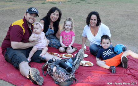 Family picnic with food and a blue ball.