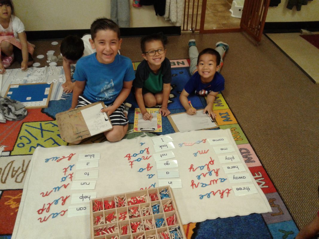 Four children learning to spell in class.