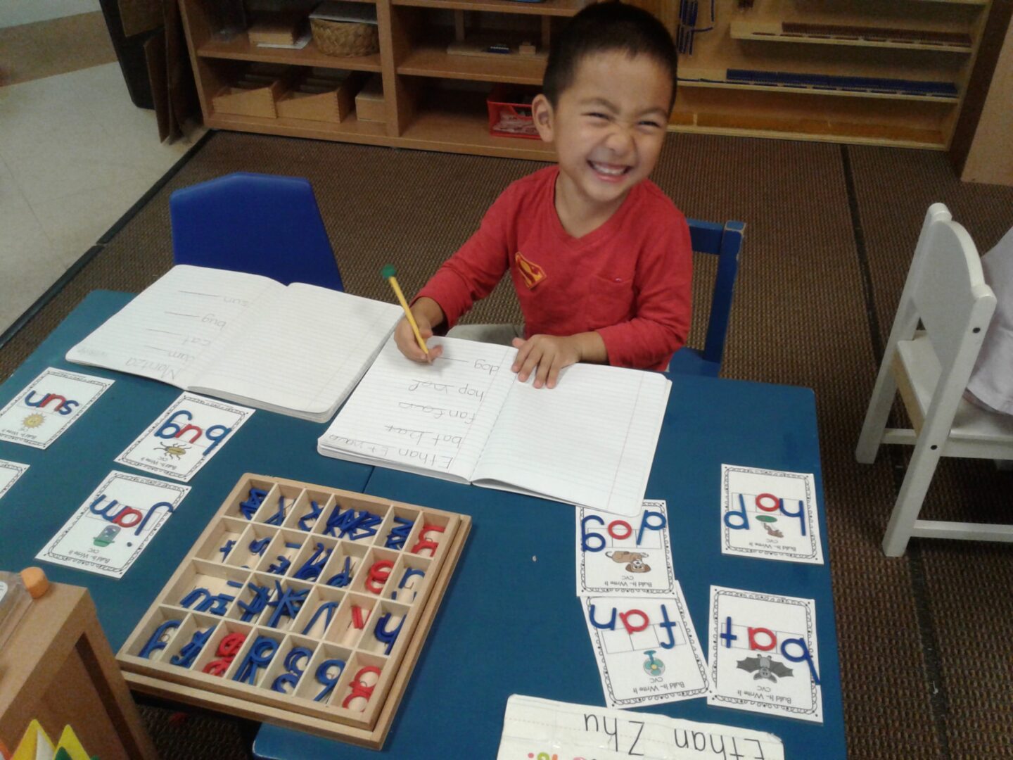 Boy smiling while learning phonics.