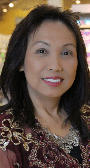 Woman with long black hair smiling in a red dress.