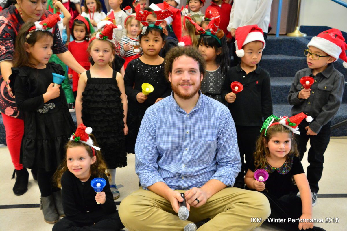 Children in Santa hats holding jingle bells.