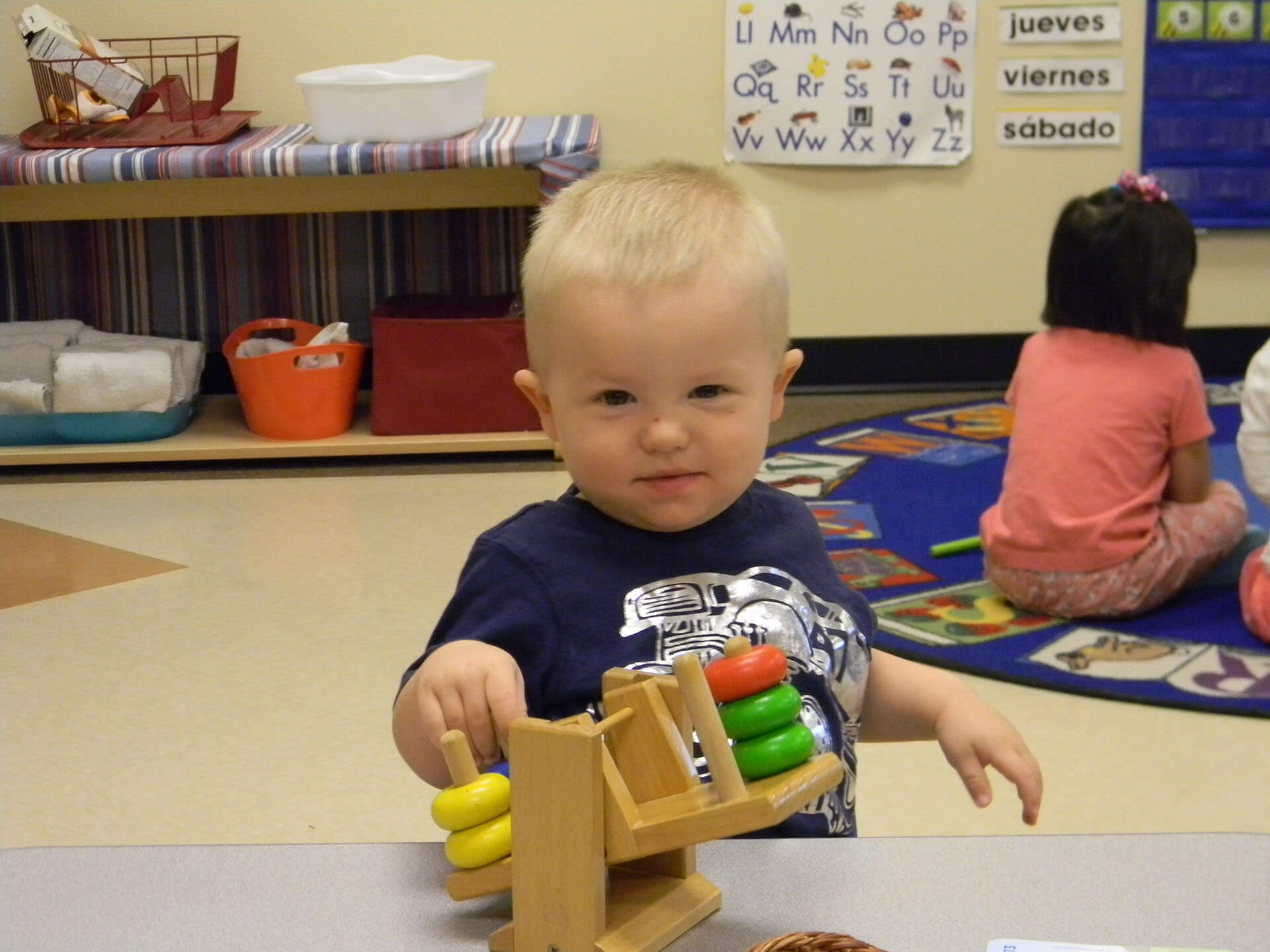 Boy playing with colorful stacking toy.