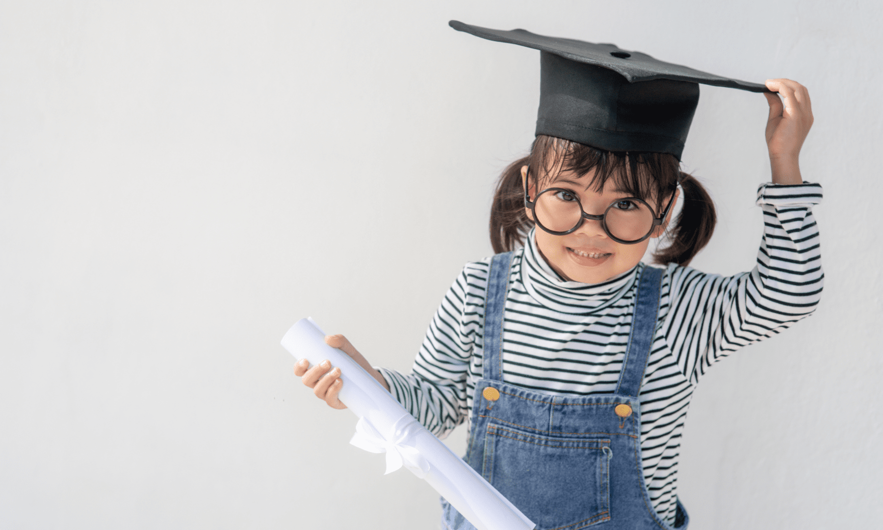 Smiling girl in cap holding diploma.