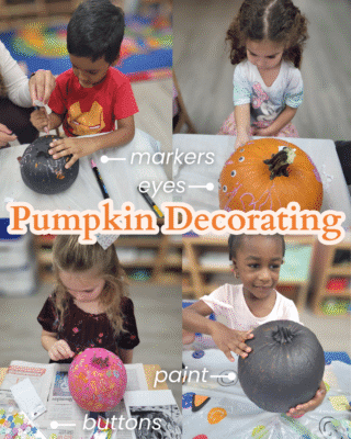 This photo shows 4 toddlers each working on decorating their pumpkins. One toddler had a pumpkin painted black and is drawing on it with markers. Another toddler is gluing googly eyes onto an unpainted pumpkin. Another toddler is gluing buttons onto a pumpkin that has been painted pink. Another toddler is holding a pumpkin that has been painted black.