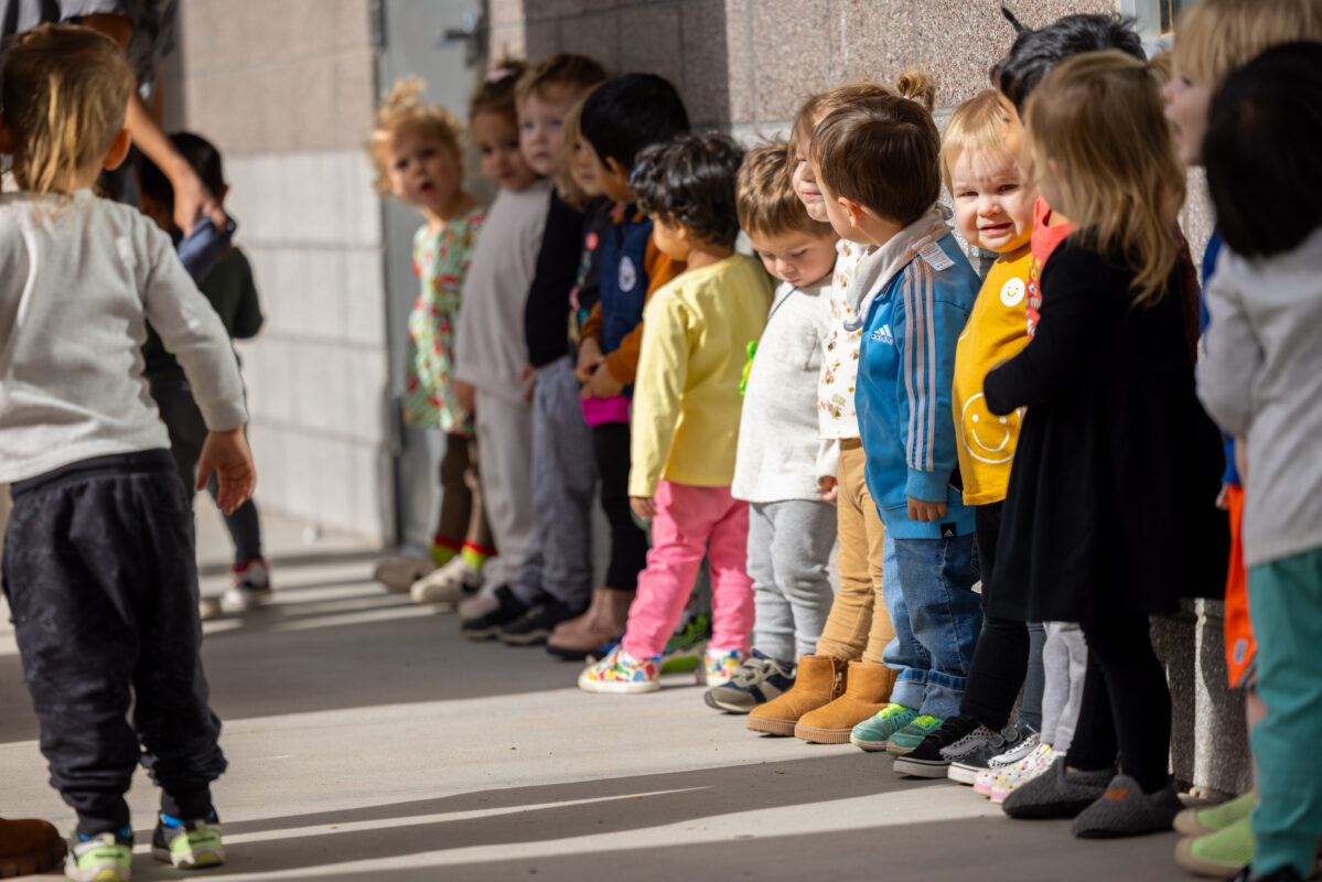 Image of 9 toddlers standing in a line